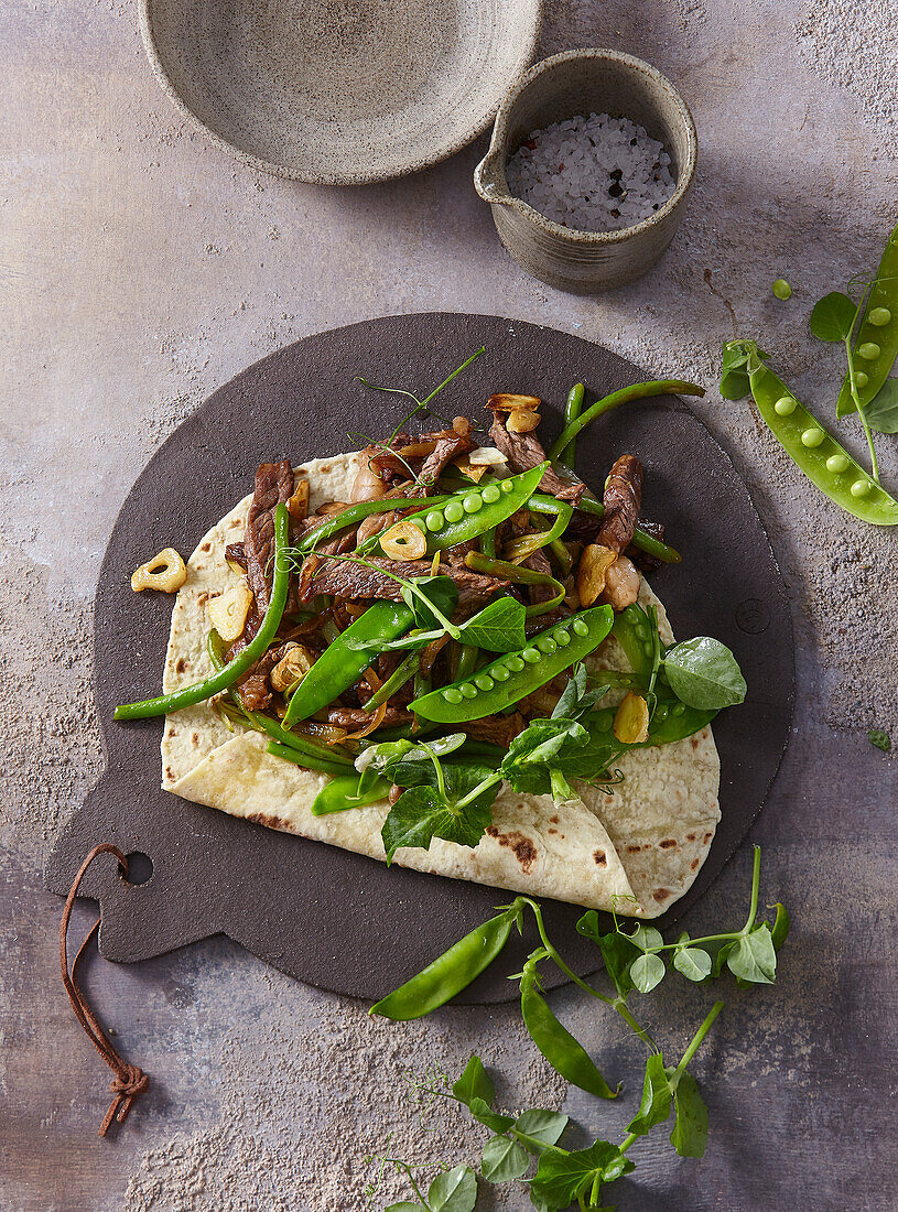 Fajitas with steak strips, green beans and peas