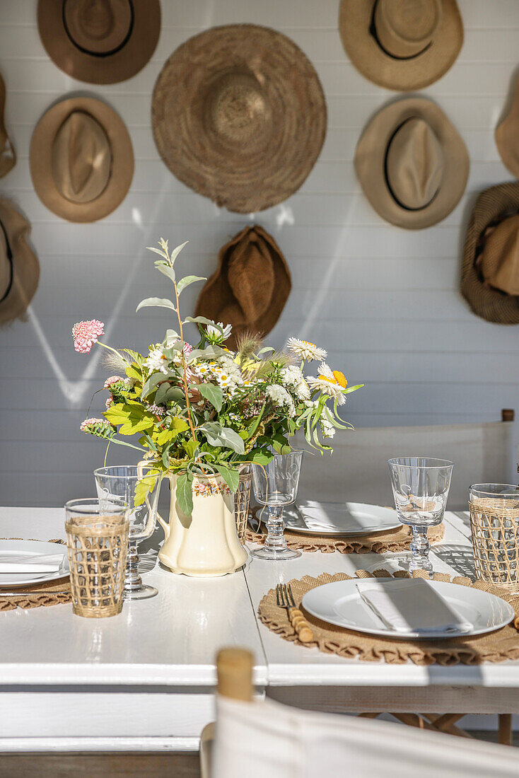 Sunny dining area and collection of hats in the wooden cottage