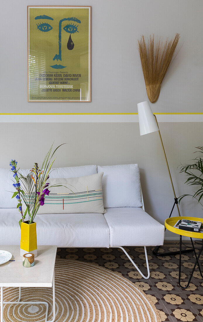 White sofa with vintage poster above in the conservatory