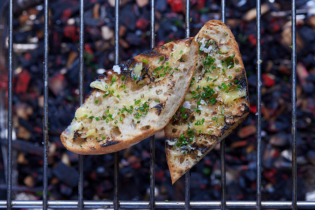 Grilled herb baguette on a grill grate