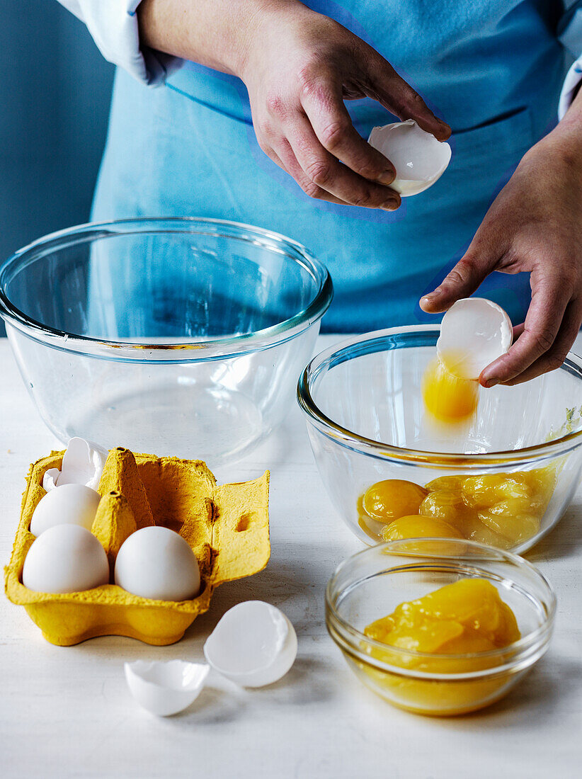 Eier aufschlagen - Eigelb und Eiweiß in getrennte Schüsseln geben