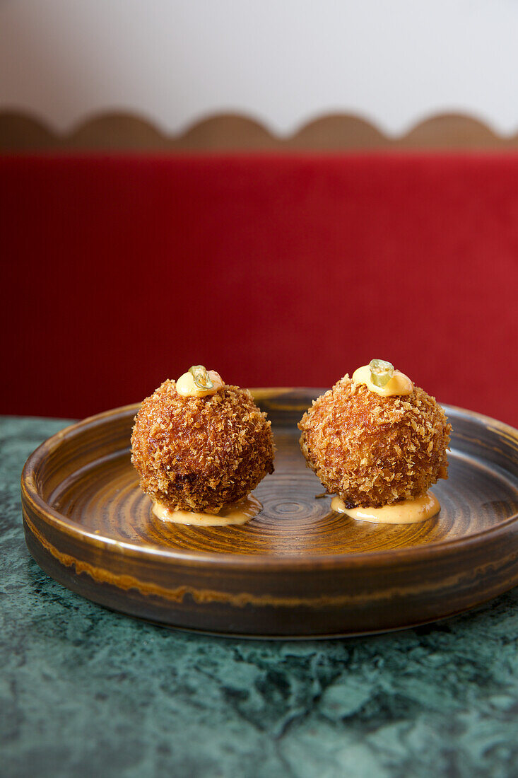 Two croquettes on a ceramic plate