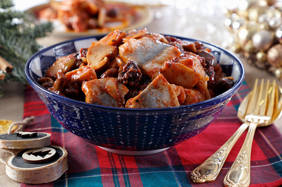 Pieces of marinated herring in tomato sauce with the addition of mushrooms and prunes