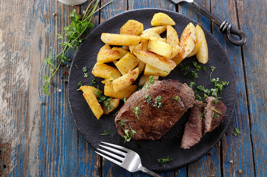 Beef steak with fried potato wedges