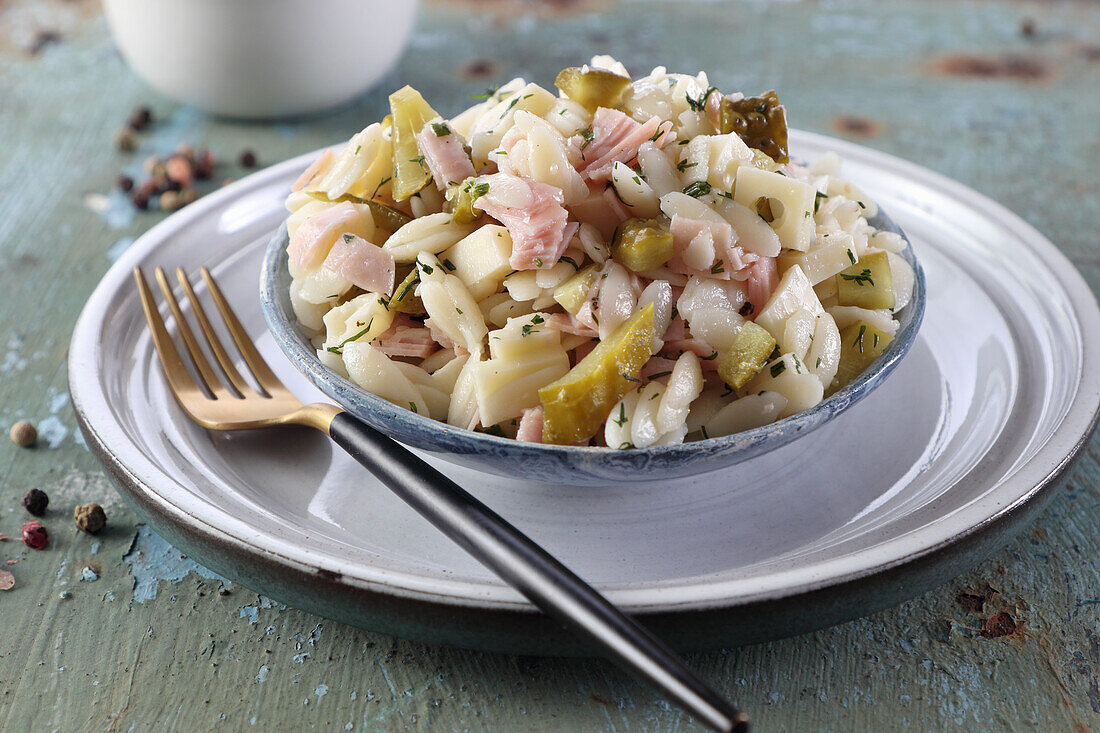 Salad with orzo noodles, ham, pickles, and cheese