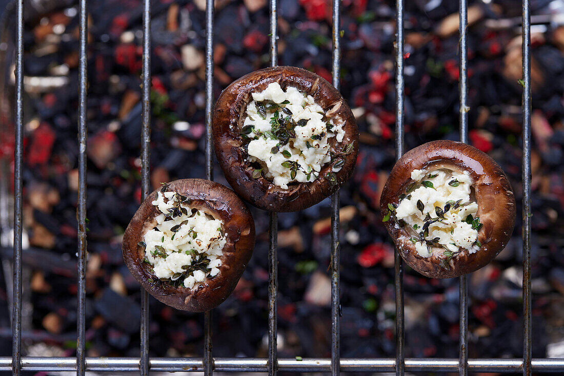 Grilled stuffed mushrooms on a grill grate