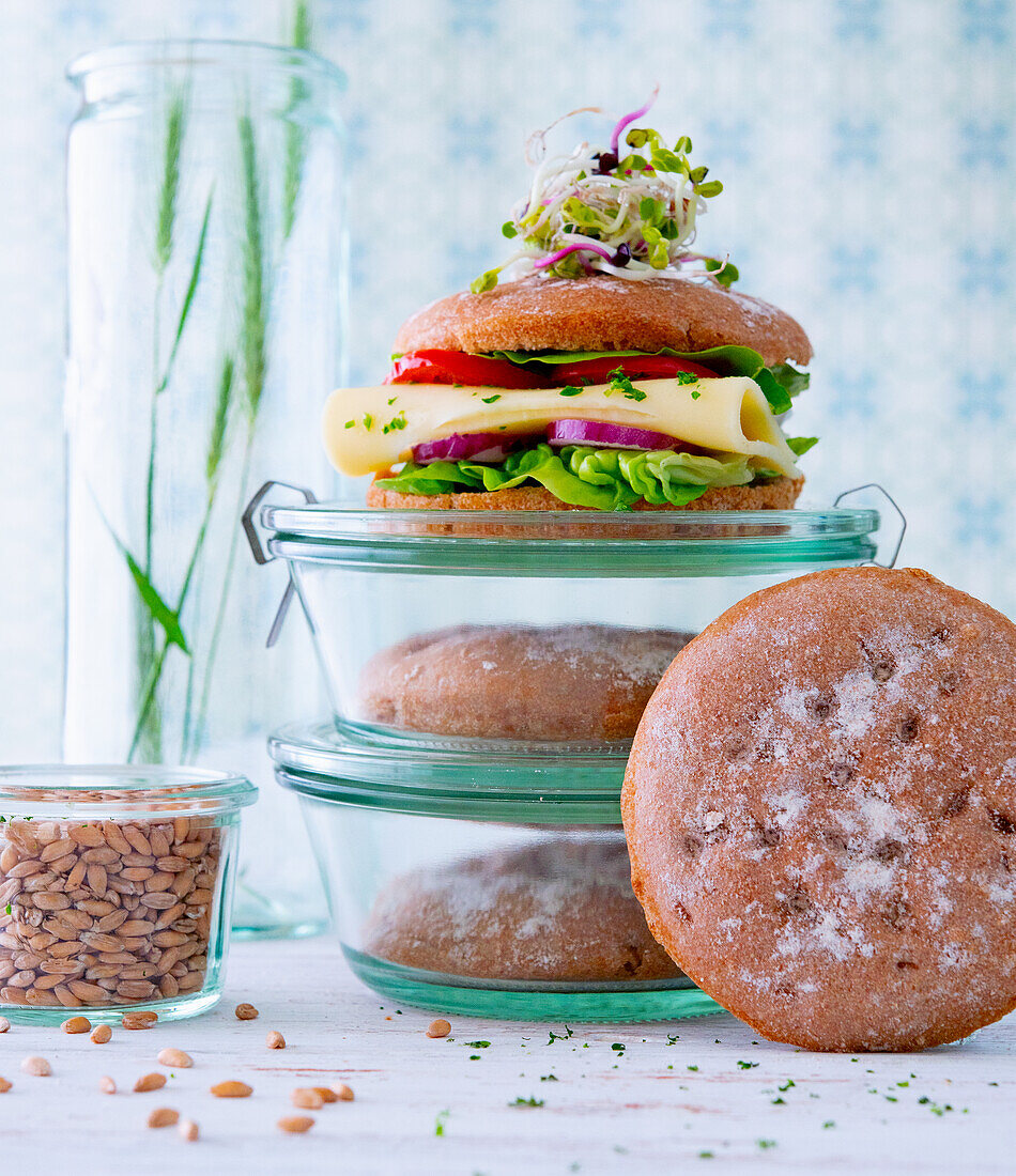 Wholemeal sandwiches stored in jars topped with cheese and vegetables