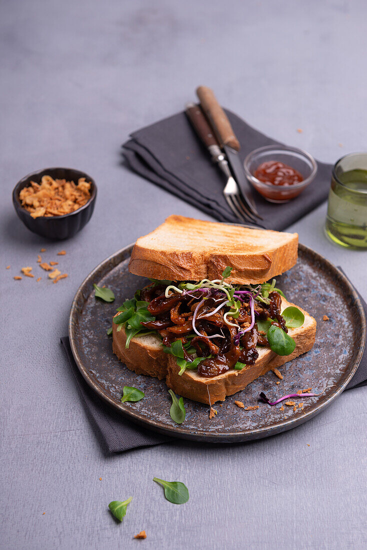 Vegan sandwich with smokey-pulled mushroom, lamb's lettuce and sprouts