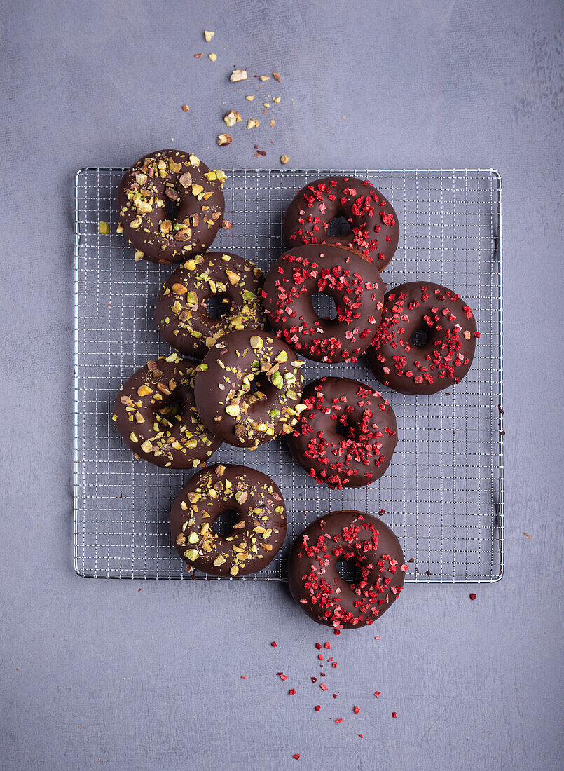 Donuts mit Schokoglasur, Pistazien und gefriergetrockneten Erdbeeren