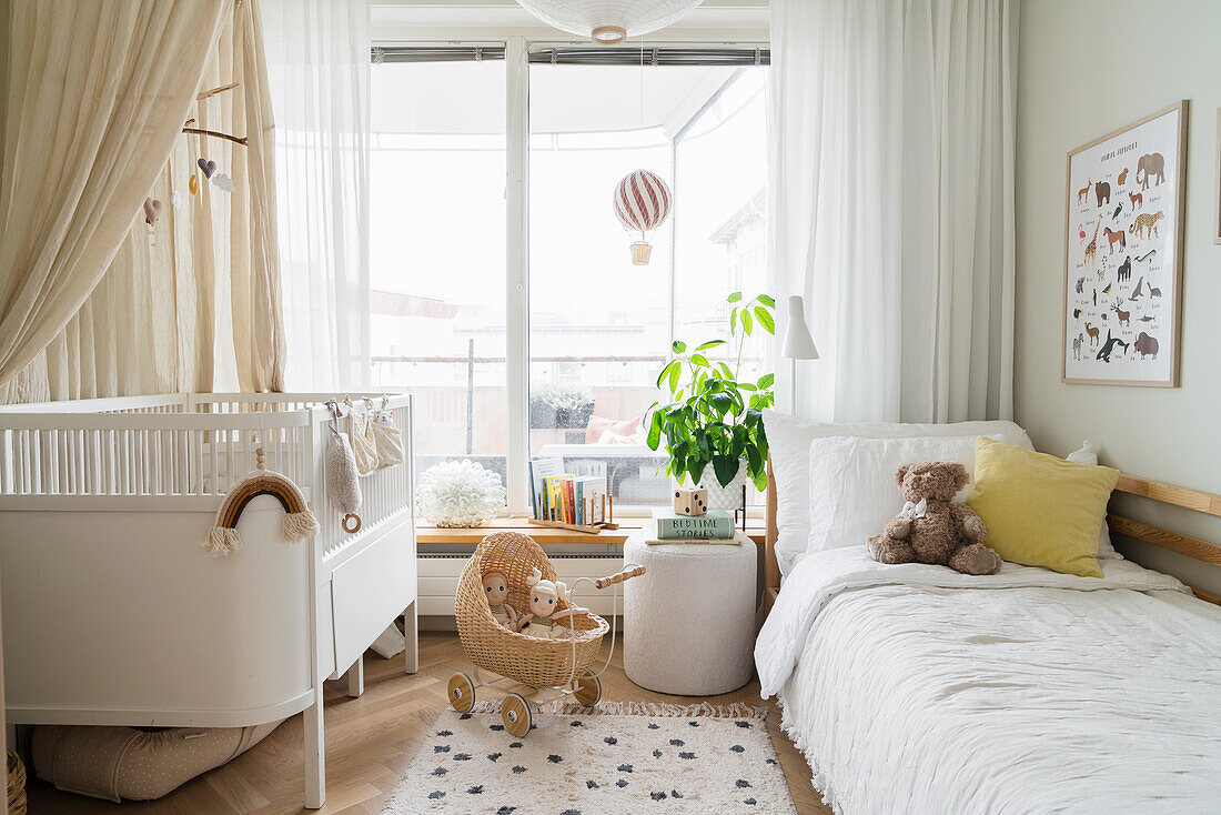 Light-flooded children's room with crib and child's bed