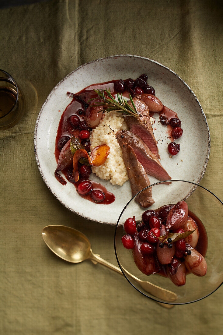 Sliced lamb fillet with a cranberry shallot sauce on pearl barley