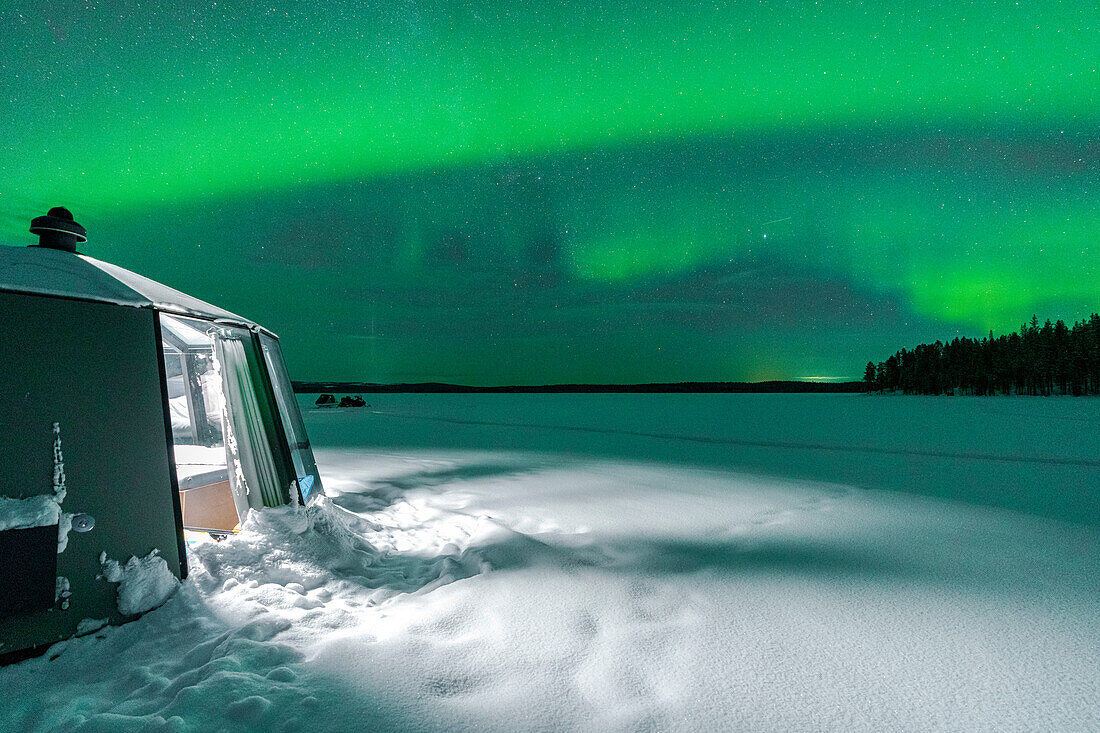 Beleuchtetes leeres Iglu in der gefrorenen Landschaft unter Aurora Borealis (Nordlicht), Jokkmokk, Lappland, Schweden, Skandinavien, Europa