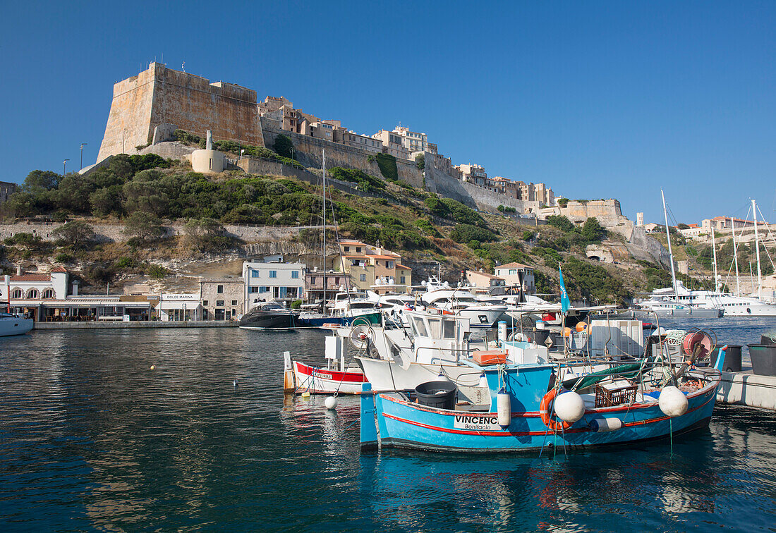 Blick über den Hafen auf die historische Zitadelle, bunte Fischerboote im Vordergrund, Bonifacio, Corse-du-Sud, Korsika, Frankreich, Mittelmeer, Europa