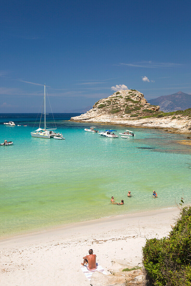 Touristen entspannen sich im seichten türkisfarbenen Wasser am Plage du Petit Loto, St-Florent, Haute-Corse, Korsika, Frankreich, Mittelmeer, Europa