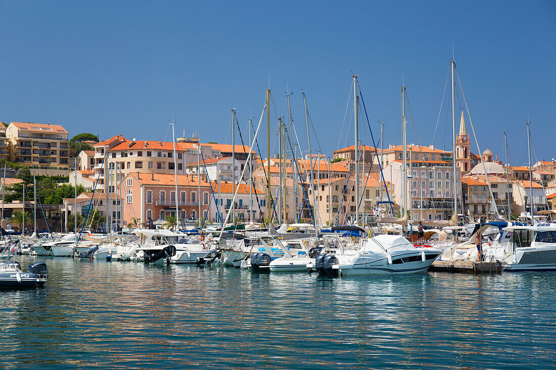 View across marina to the town, yachts and motor boats reflected in tranquil water, Calvi, Haute-Corse, Corsica, France, Mediterranean, Europe