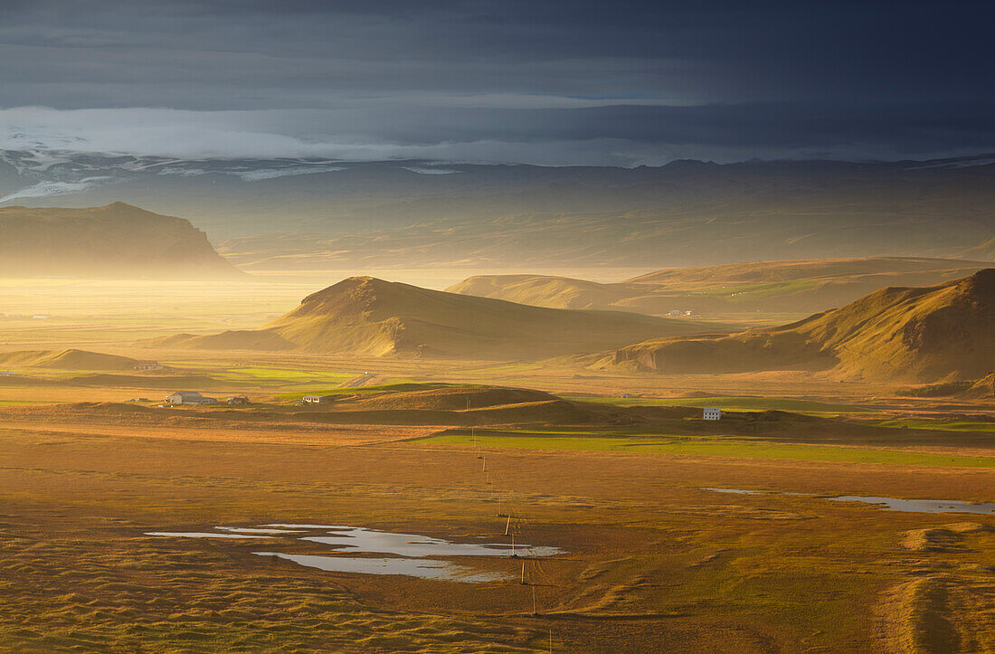 Ein Blick ins Landesinnere auf den Mydralsjokull, von der Insel Dyrholaey aus gesehen, kurz vor Sonnenuntergang, in der Nähe von Vik, Südisland, Polarregionen