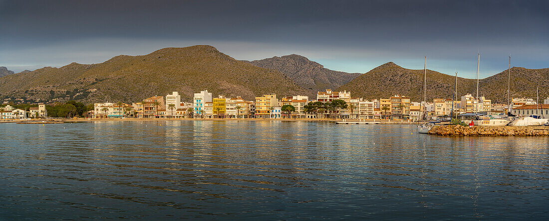 Blick auf den Sonnenaufgang, der sich in den Hotels und Bars in Port de Pollenca spiegelt, Port de Pollenca, Mallorca, Balearen, Spanien, Mittelmeer, Europa