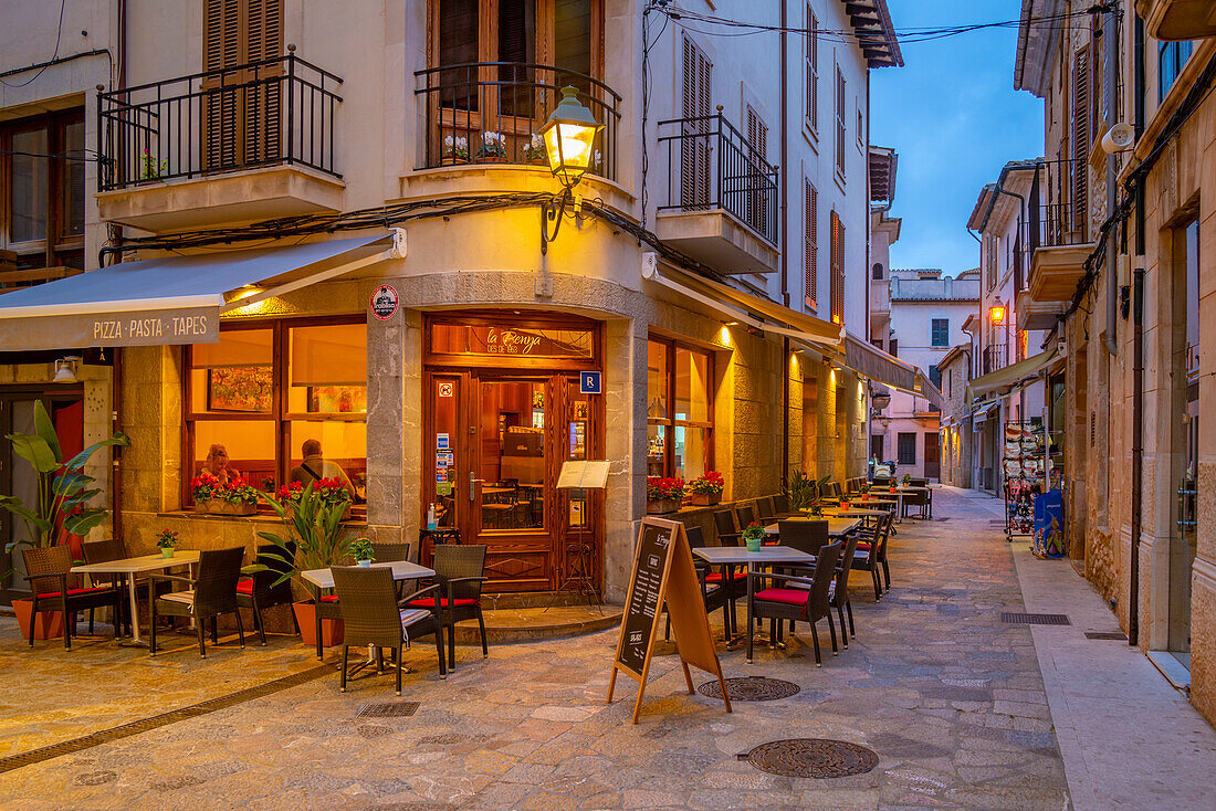 Blick auf eine Bar in einer engen Gasse in der Altstadt von Pollenca in der Abenddämmerung, Pollenca, Mallorca, Balearen, Spanien, Mittelmeer, Europa