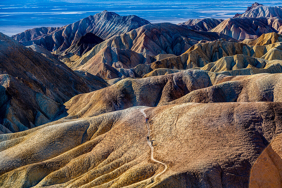 Hikers in the colourful sandstone formations, Zabriskie Point, Death Valley, California, United States of America, North America