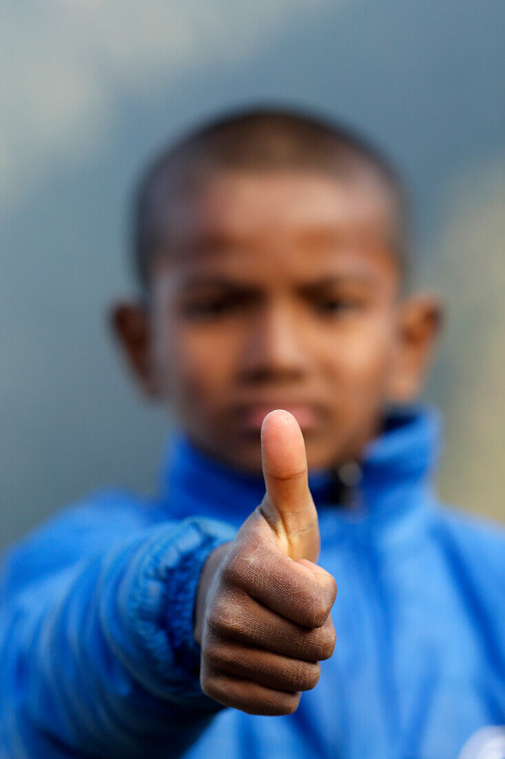 Rehabilitation center for street children, portrait of boy giving thumbs up, positive sign of agreement and like, Nepal, Asia