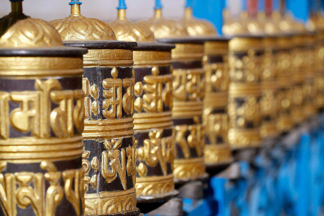 Rolling metal prayer wheels circling, with mantra written in Tibetan language, Shakhya Tharig Buddhist Monastery, Kathmandu, Nepal, Asia