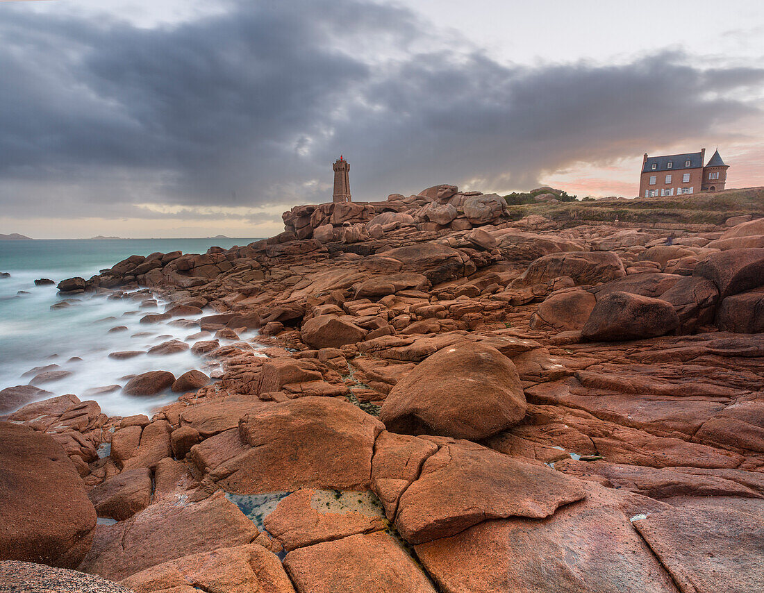 Sunrise long exposure at Ploumanach lighthouse and a house over the pink granite coast, Cotes d'Armor, Brittany, France, Europe