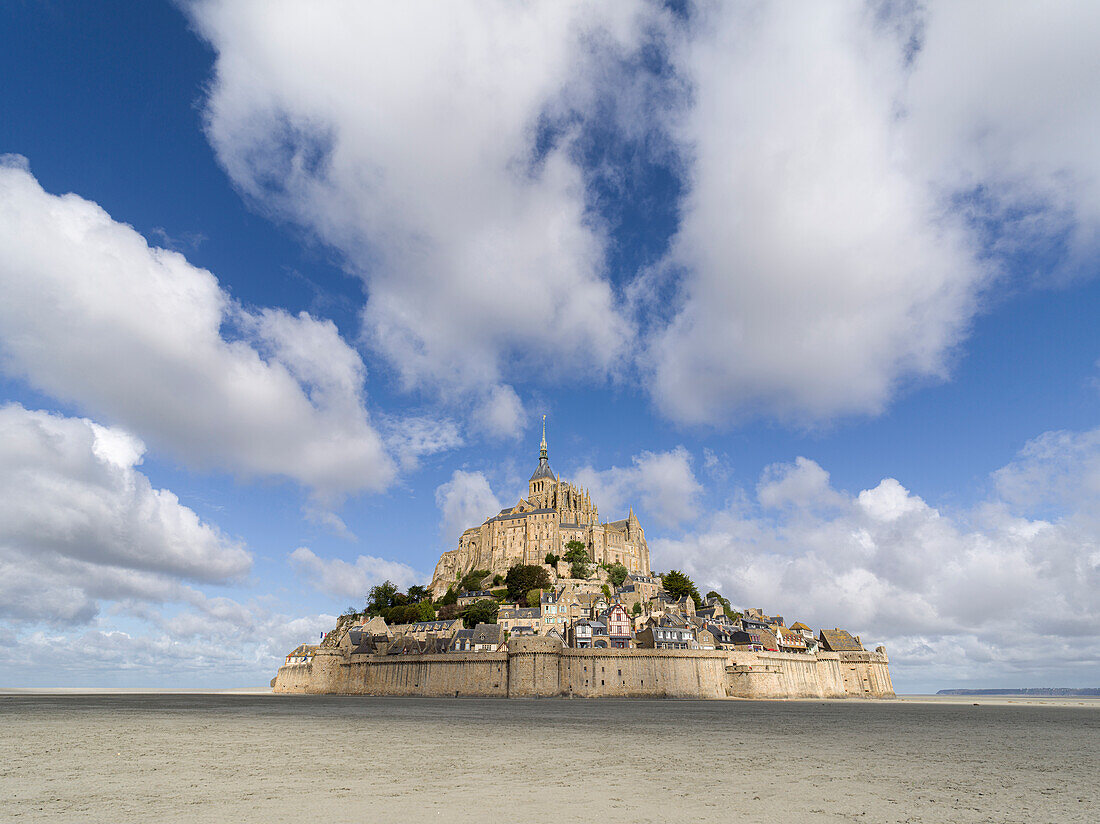 Mont Saint Michel, UNESCO World Heritage Site, at low tide day with a blue sky with clouds, Normandy, France, Europe