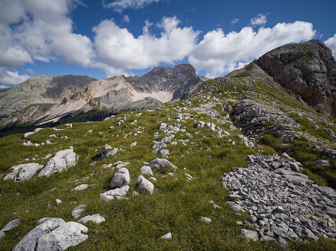 Felsen und Steine auf der Croda de R'Ancora mit Blick auf die Croda Rossa d'Ampezzo im Hintergrund, blauer Himmel mit weißen Wolken, Dolomiten, Italien, Europa