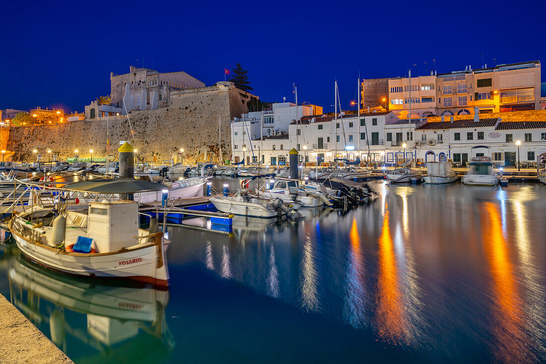 Blick auf Boote im Yachthafen mit Blick auf weiß getünchte Gebäude in der Abenddämmerung, Ciutadella, Menorca, Balearen, Spanien, Mittelmeer, Europa