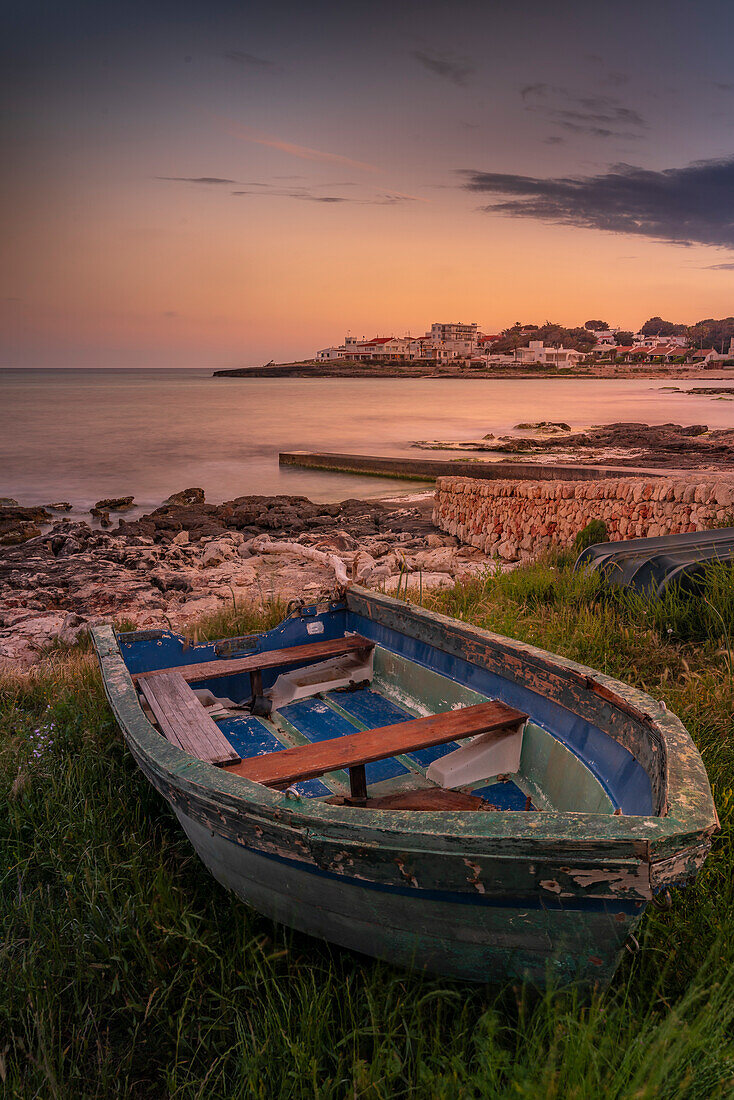 Blick auf Playa Punta Prima und Ruderboot in der Abenddämmerung, Punta Prima, Menorca, Balearische Inseln, Spanien, Mittelmeer, Europa