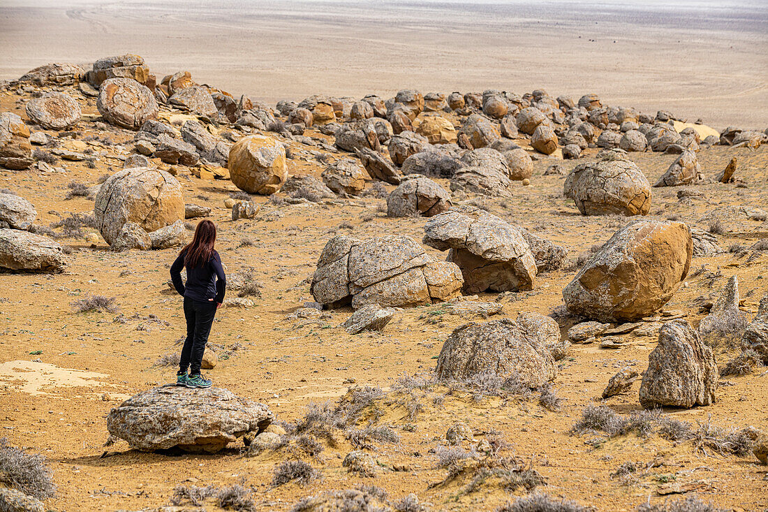 Woman standing in the Torysh (The Valley of Balls), Shetpe, Mangystau, Kazakhstan, Central Asia, Asia