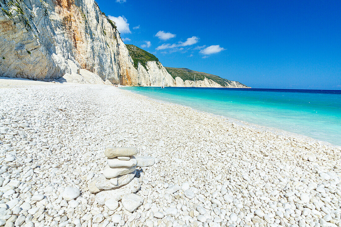 Strahlende Sonne auf weißen Kieseln am Strand von Fteri, umspült vom türkisfarbenen Meer, Kefalonia, Ionische Inseln, Griechische Inseln, Griechenland, Europa