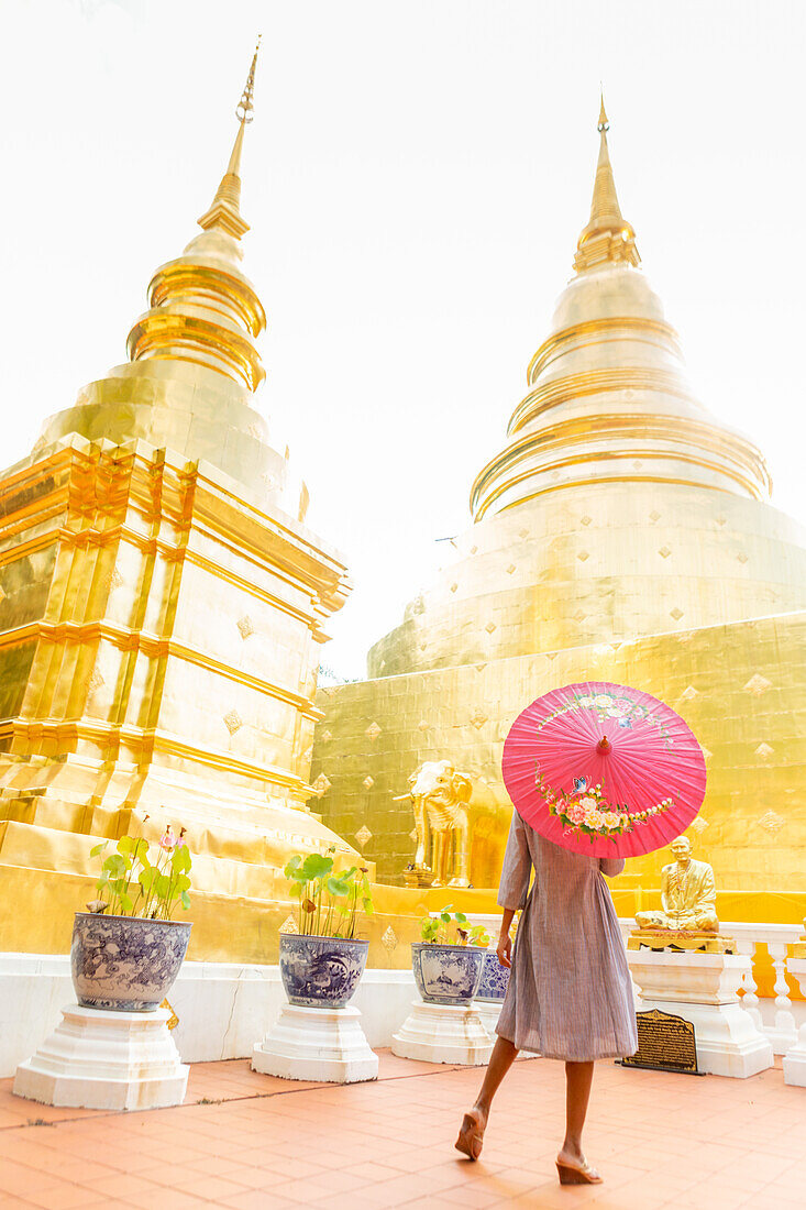 Woman with red umbrella at Wat Phra Singh Woramahawihan, Chiang Mai, Thailand, Southeast Asia, Asia