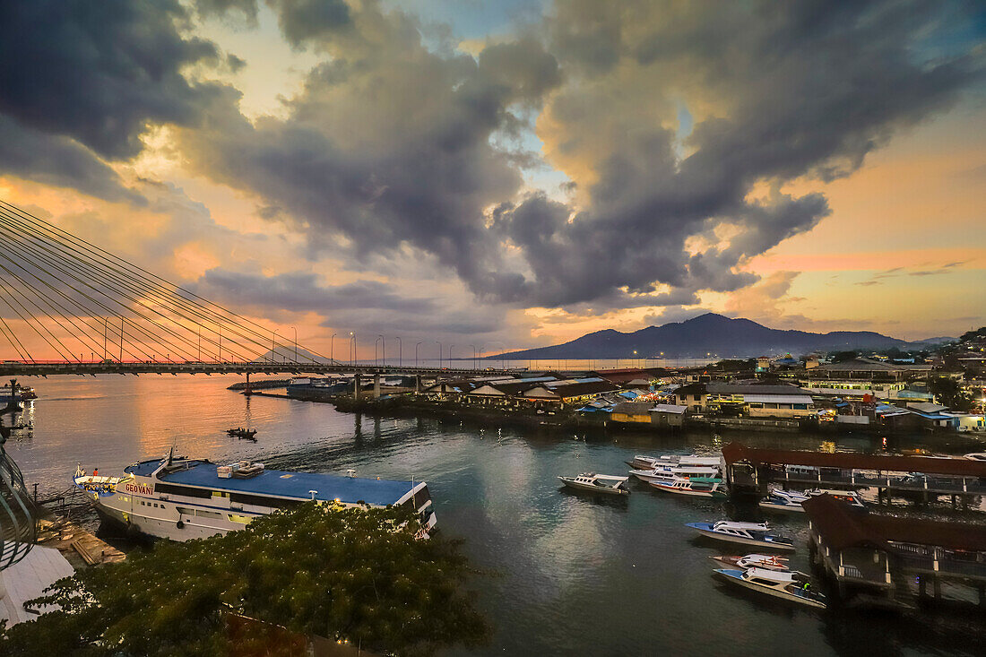 Der Hafen von Manado und die Soekarno-Brücke bei Sonnenuntergang in der Provinzhauptstadt im hohen Norden von Sulawesi, Manado, Nordsulawesi, Indonesien, Südostasien, Asien