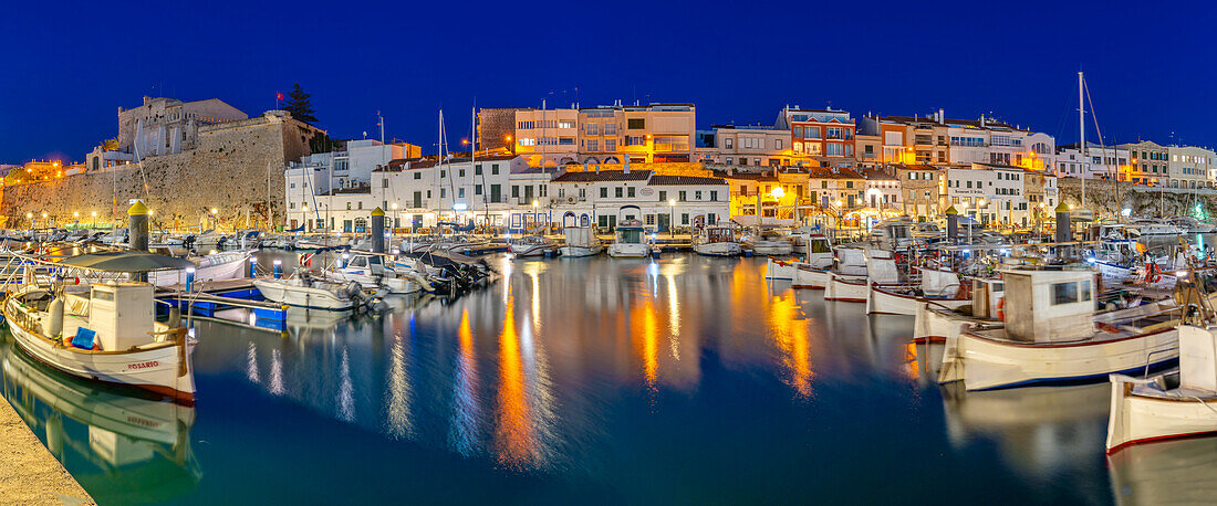 Blick auf Boote im Yachthafen mit Blick auf weiß getünchte Gebäude in der Abenddämmerung, Ciutadella, Menorca, Balearen, Spanien, Mittelmeer, Europa