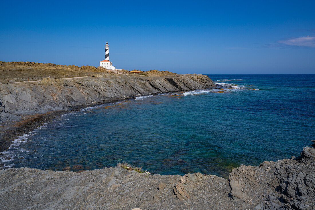 View of Far de Favaritx striped lighthouse on rocky headland, Carretera Favaritx, Menorca, Balearic Islands, Spain, Mediterranean, Europe
