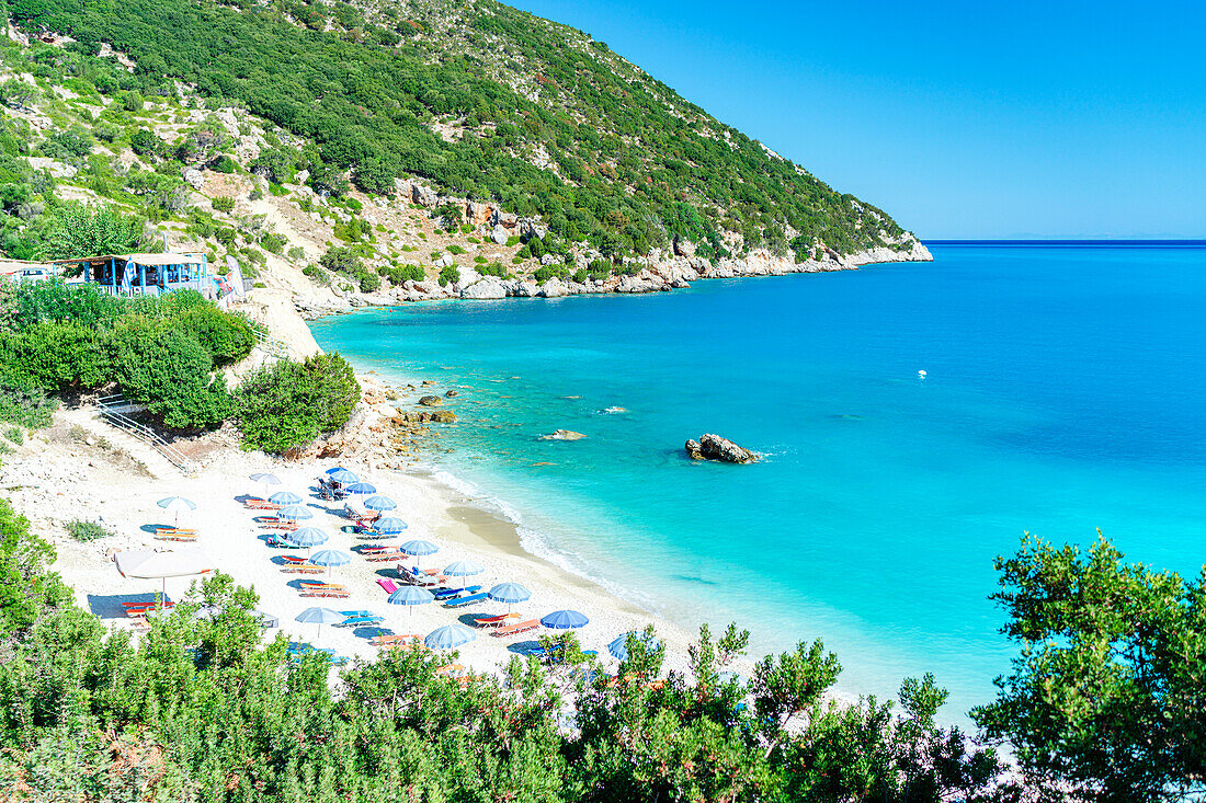 Blick aus der Vogelperspektive auf Sonnenschirme am idyllischen Strand von Vouti, umrahmt von üppigen Pflanzen, Zola, Kefalonia, Ionische Inseln, Griechische Inseln, Griechenland, Europa