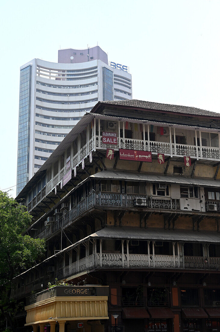 Moderner BSE-Wolkenkratzer, ehemals Bombay Stock Exchange, überschattet heruntergekommenes dreistöckiges Gebäude aus der Raj-Ära darunter, Mumbai, Indien, Asien