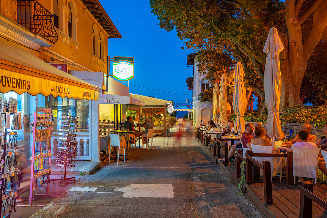 Blick auf Café und Restaurant in der Nähe des Hafens in der Abenddämmerung, Lovran Dorf, Lovran, Kvarner Bucht, Ost-Istrien, Kroatien, Europa