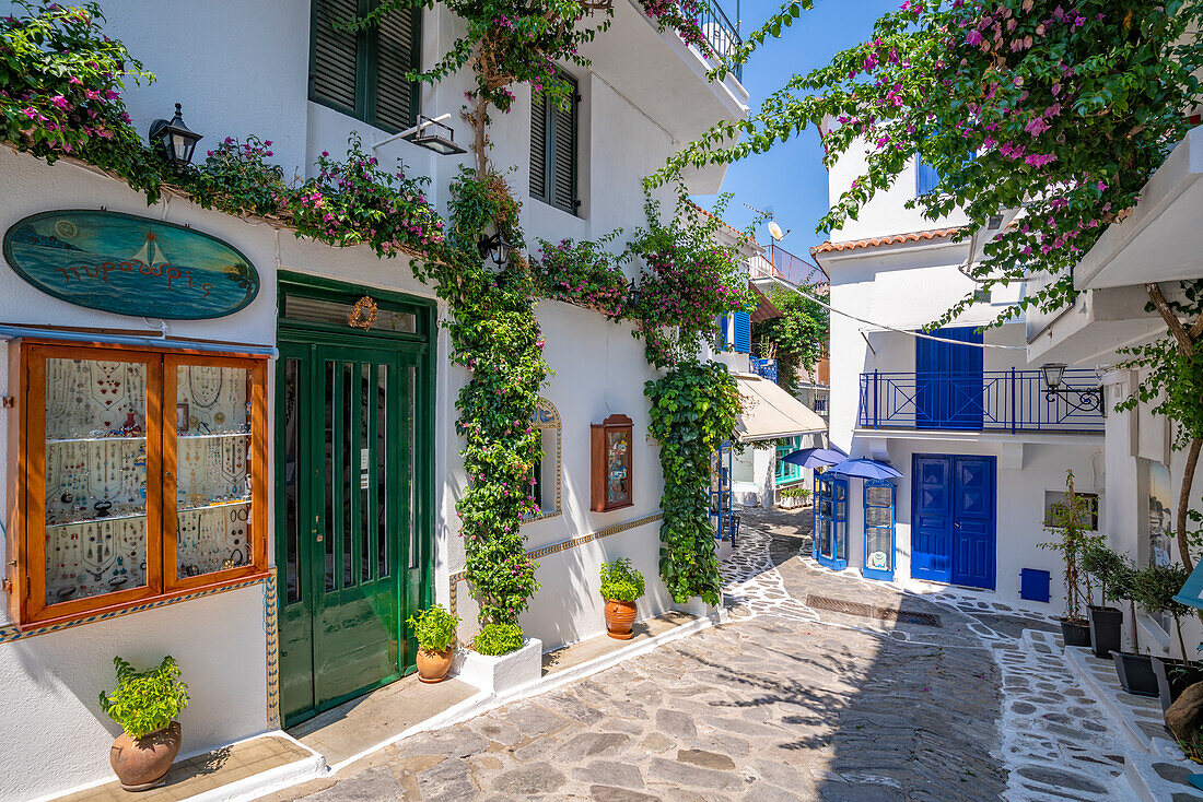 Blick auf eine enge, weiß getünchte Straße in Skiathos-Stadt, Insel Skiathos, Sporaden, Griechische Inseln, Griechenland, Europa