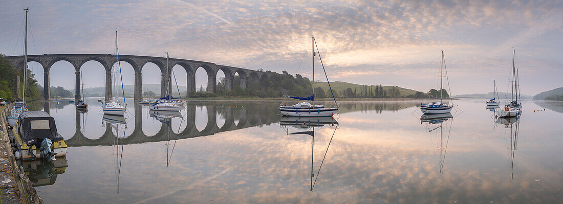 Boote auf dem Fluss Tiddy in der Morgendämmerung unterhalb des viktorianischen Viadukts bei St. Germans, Cornwall, England, Vereinigtes Königreich, Europa