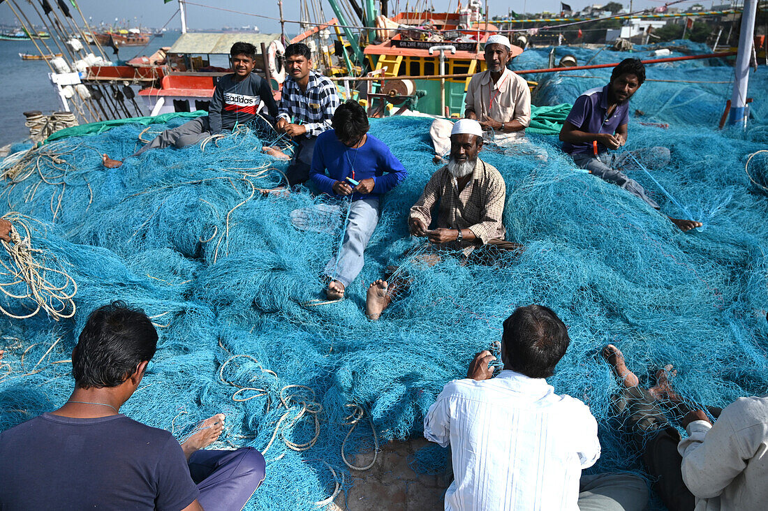 Fischernetze werden von muslimischen Fischern am Kai der Insel Bet Dwaraka ausgebessert, Dwarka, Gujarat, Indien, Asien