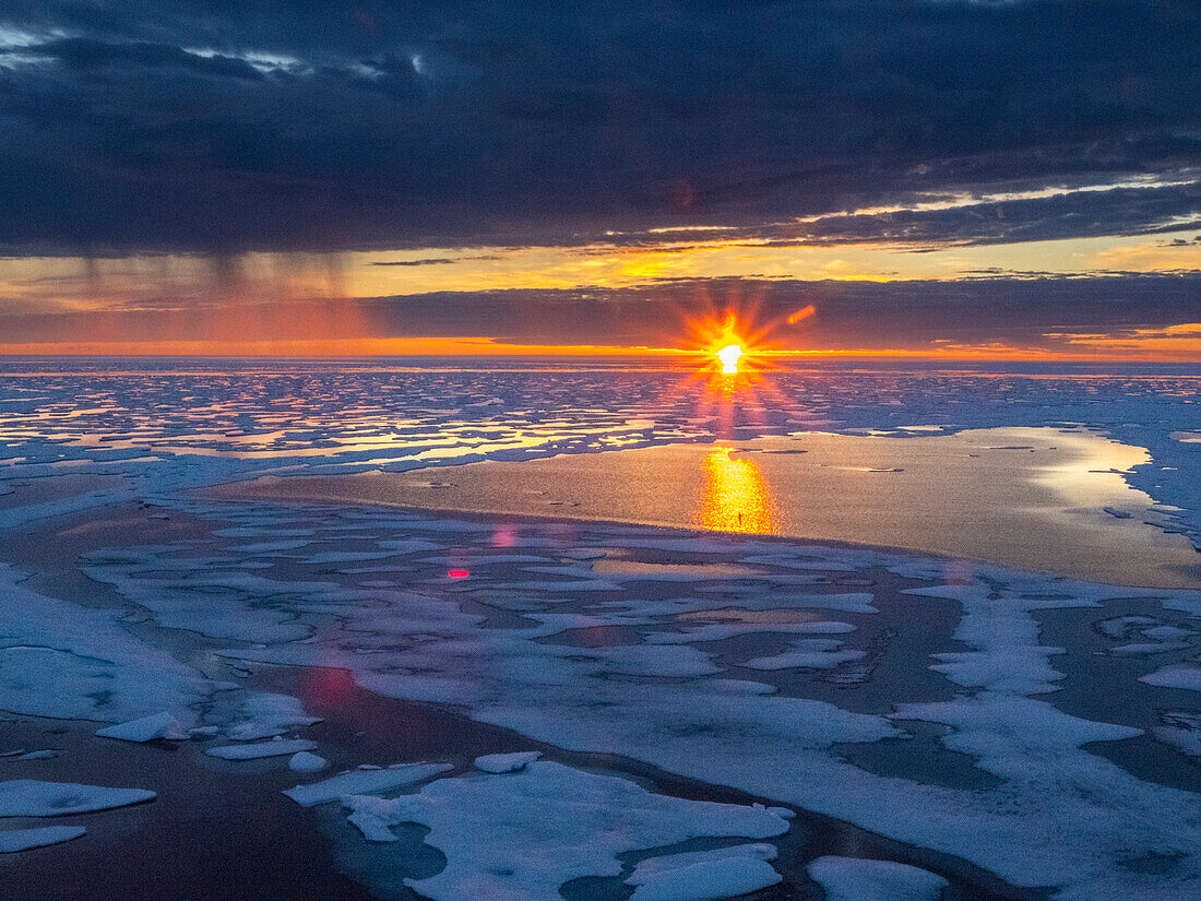 Sonnenuntergang und Regenschauer im schweren Packeis im McClintock-Kanal, Nordwestpassage, Nunavut, Kanada, Nordamerika