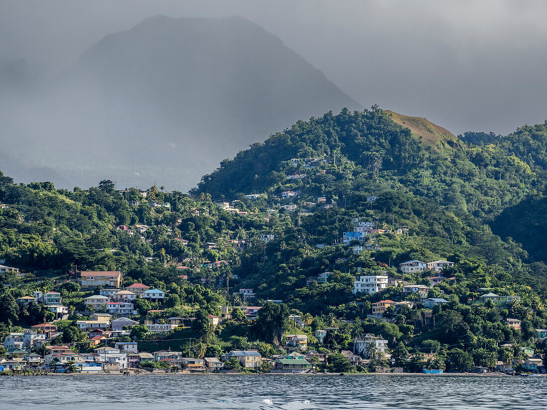 A view from the sea of the lush mountains surrounding the capital city of Roseau, on the west coast of Dominica, Windward Islands, West Indies, Caribbean, Central America