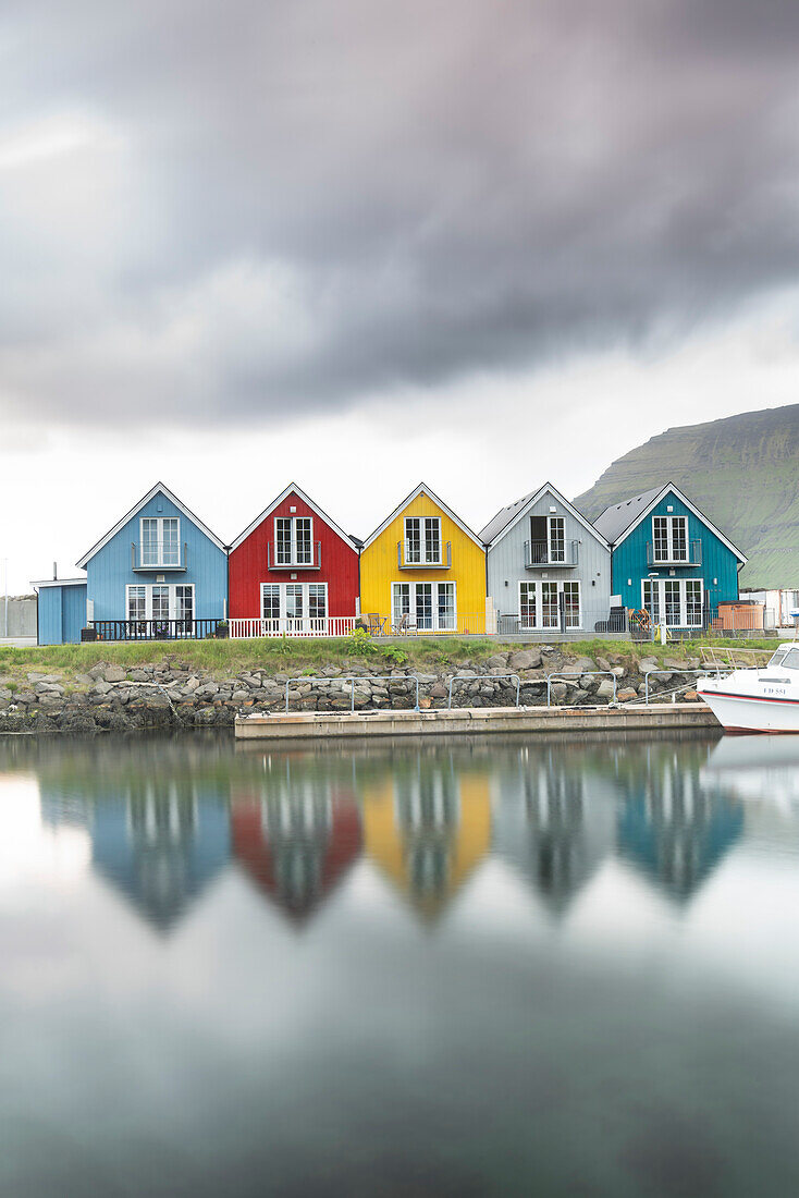 Traditionelle und farbenfrohe Hütten an der Küste von Leirvik und Spiegelung, Eysturoy Insel, Färöer Inseln, Dänemark, Europa
