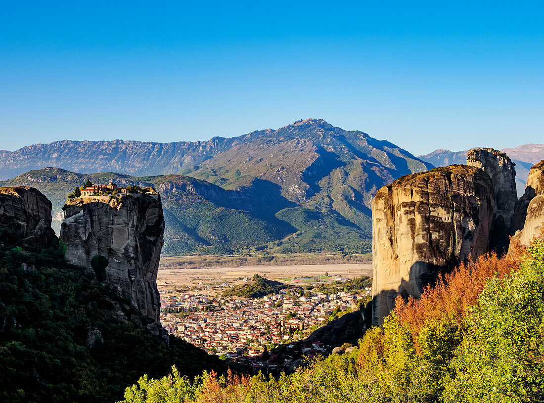 View towards the Monastery of the Holy Trinity and Kalabaka at sunrise, Meteora, UNESCO World Heritage Site, Thessaly, Greece, Europe