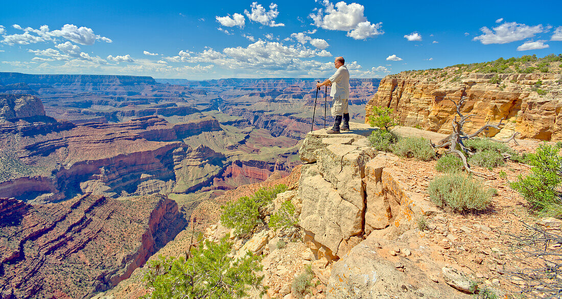 A hiker looking west from a cliff near Zuni Abyss at Grand Canyon, Zuni Point in the background just right of center, Grand Canyon National Park, UNESCO World Heritage Site, Arizona, United States of America, North America