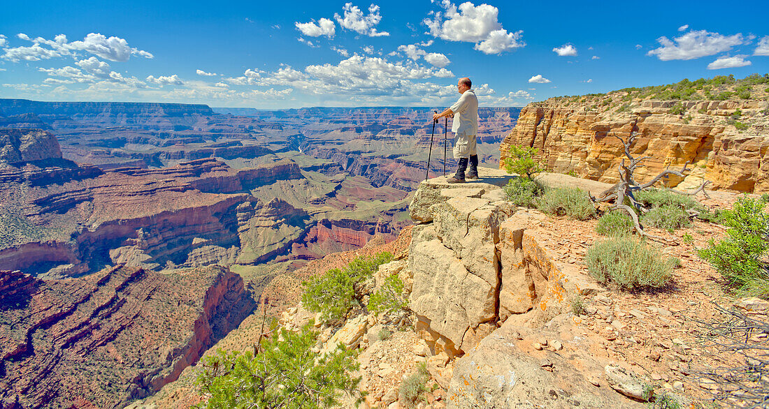 Ein Wanderer blickt von einer Klippe in der Nähe des Zuni Abyss am Grand Canyon nach Westen, Zuni Point im Hintergrund rechts von der Mitte, Grand Canyon National Park, UNESCO-Weltnaturerbe, Arizona, Vereinigte Staaten von Amerika, Nordamerika