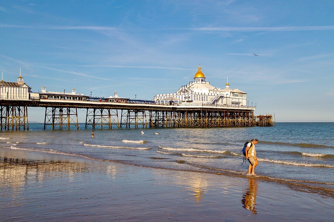Spaziergänger am Strand von Eastbourne Pier bei Sonnenuntergang, Eastbourne, East Sussex, England, Vereinigtes Königreich, Europa