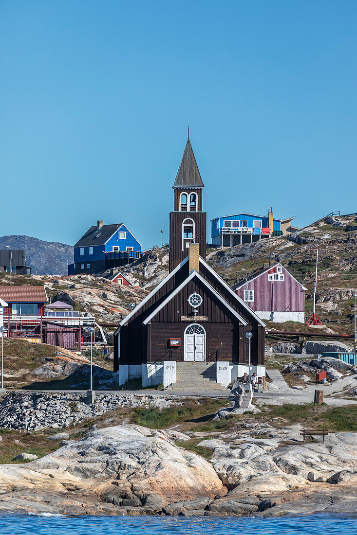 Blick auf die Zionskirche, umgeben von bunt bemalten Häusern in der Stadt Ilulissat, Grönland, Dänemark, Polarregionen